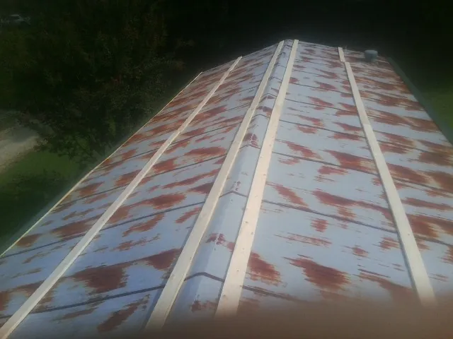 Rusted metal roof panels with new wood purlins before replacement — Storm Damage Roof Repair in Enigma by Roofing Brothers
